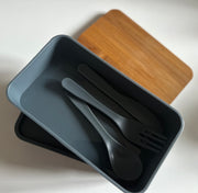 Two-tier lunch box with wooden lid and travel cutlery